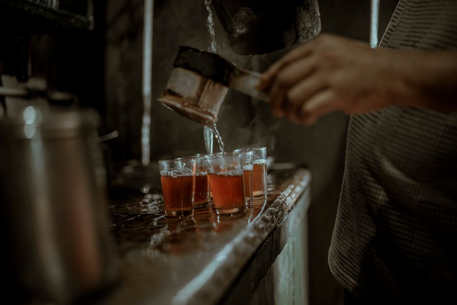 Close-up of tea being poured into glasses in Darjeeling, capturing India's tea culture.